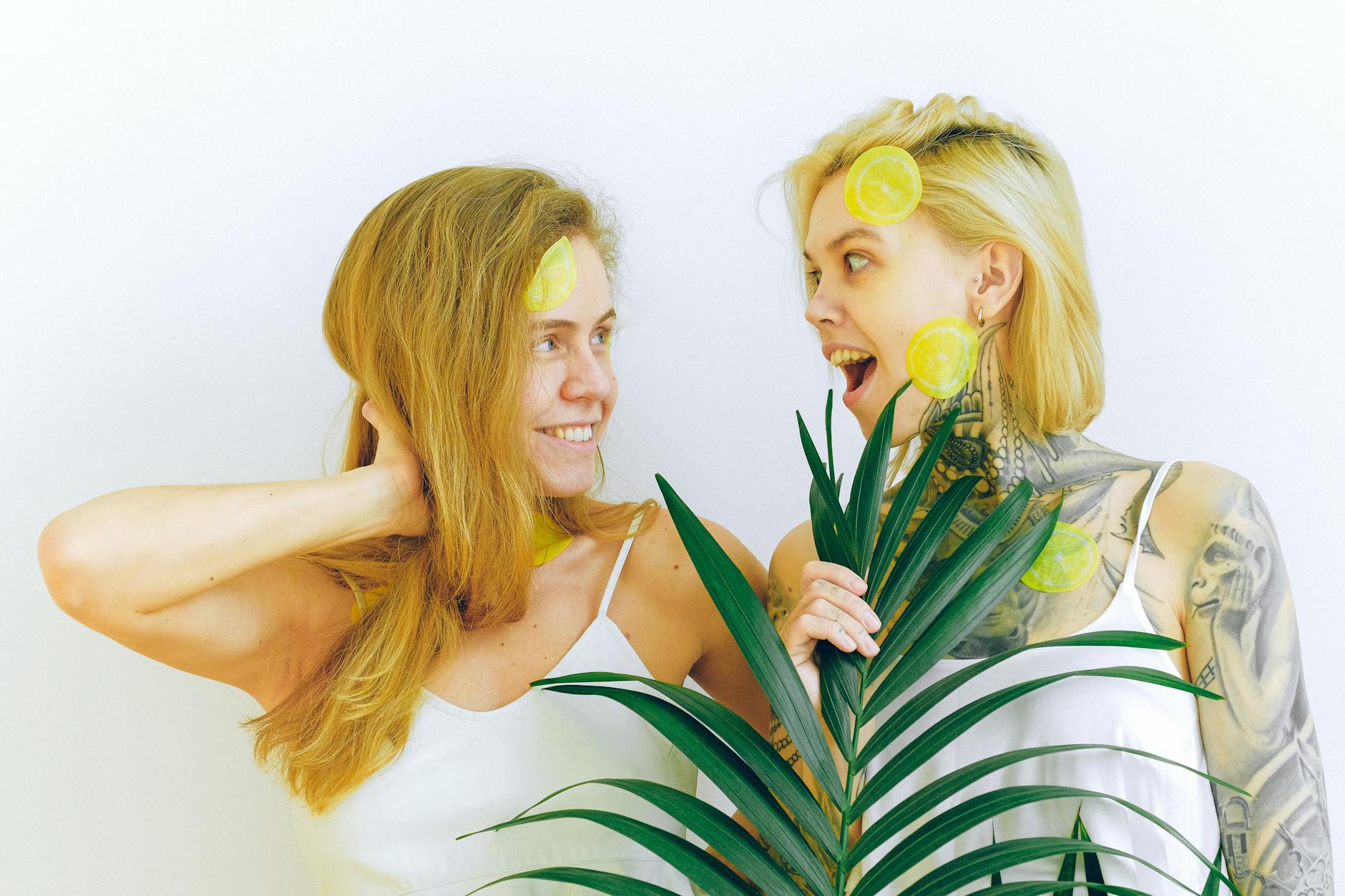 Due donne sorridenti con fette di limone che esprimono gioia e divertimento
