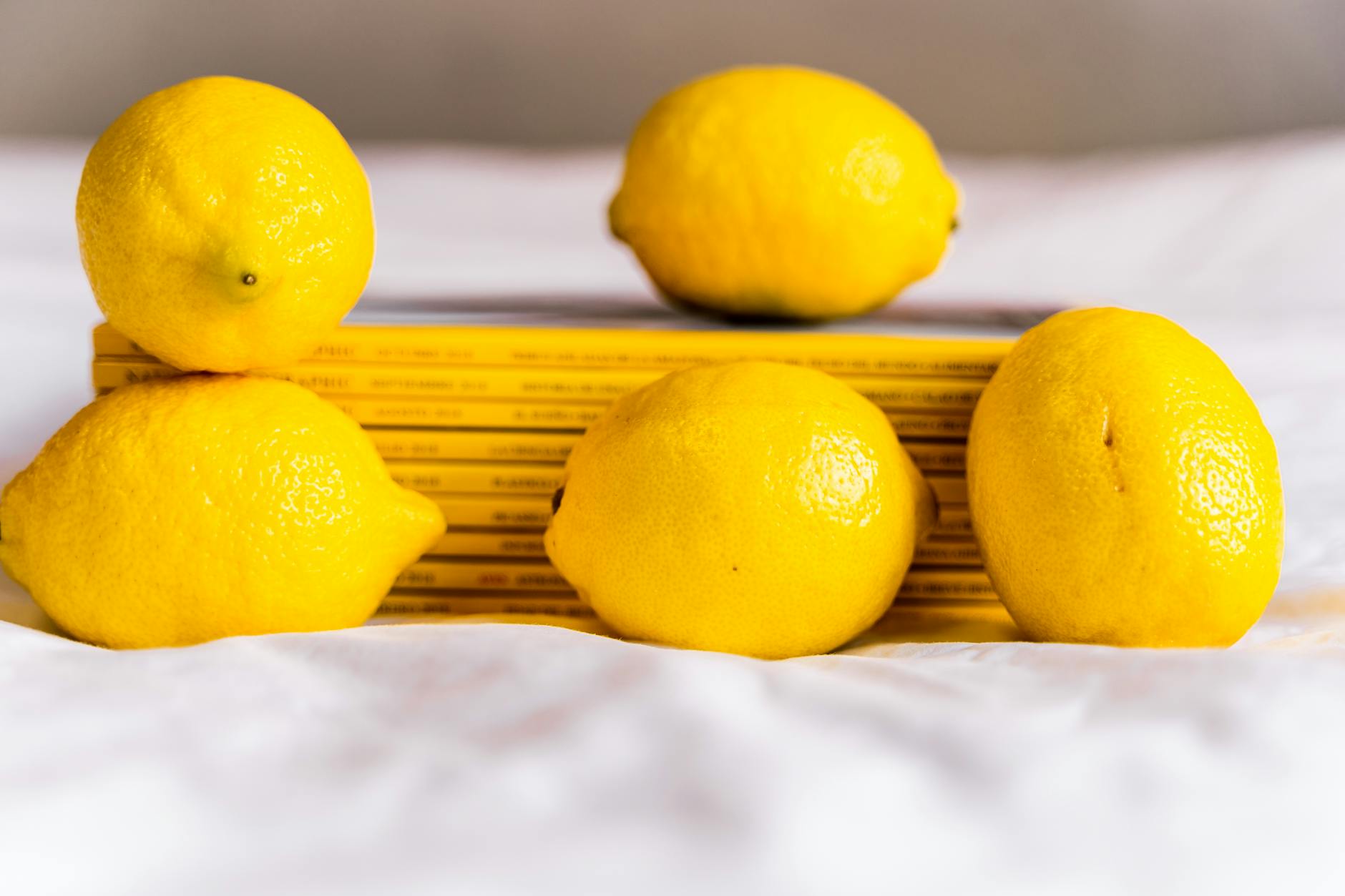 Una mano che tiene un limone fresco su uno sfondo giallo acceso, simbolo di freschezza e nuovo inizio
